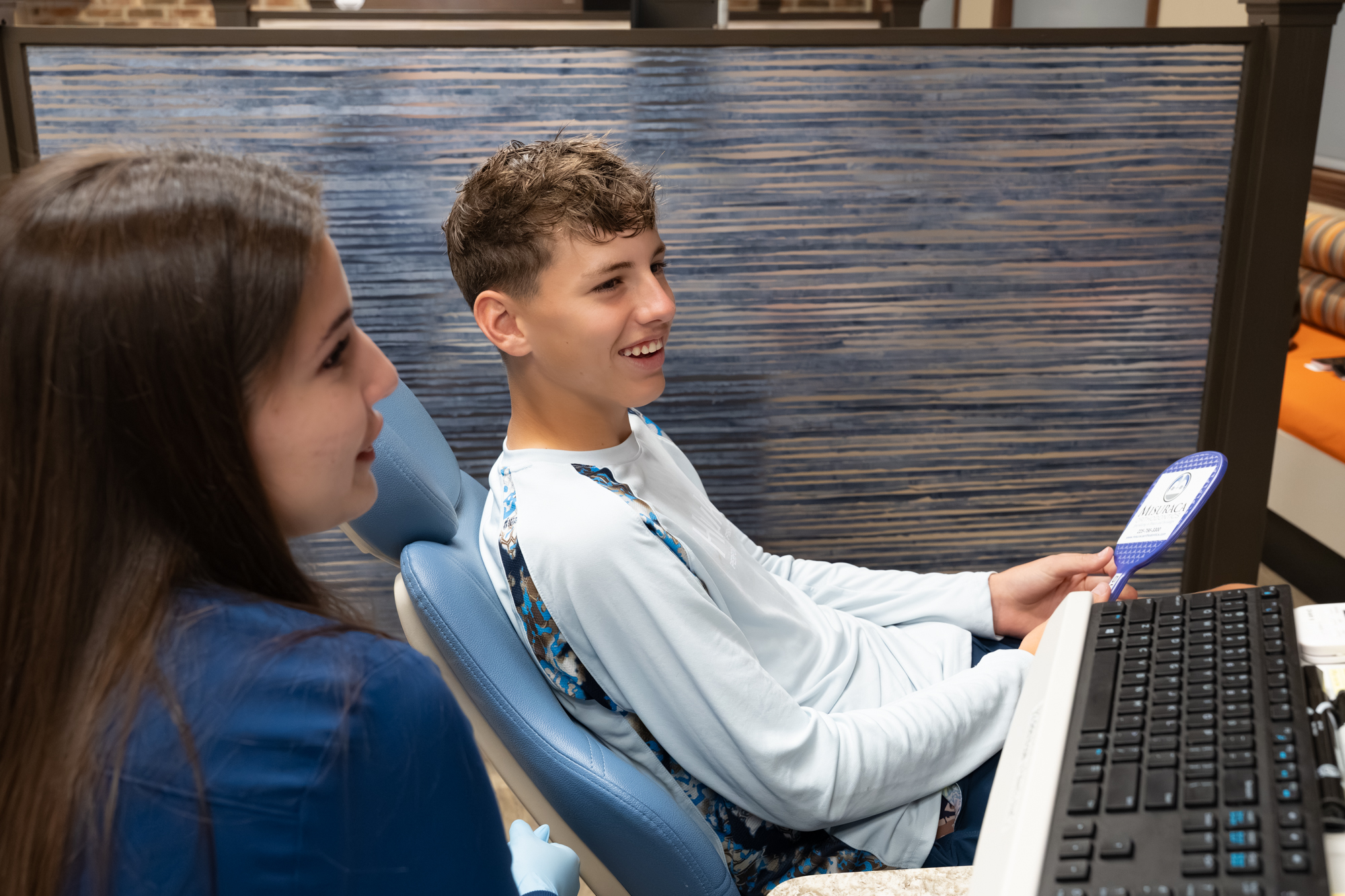 Dr. Misuraca orthodontist examining smiling patient in Denham Springs, LA office.